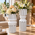 Deux vases blancs aux motifs de lignes noires et aux formes sculpturales, décorés de bouquets