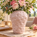 Vase décoratif rose pâle avec surface brillante ornée de petits reliefs