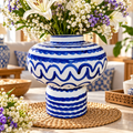 Vase blanc et bleu au motif ondulé avec un bouquet de fleurs, décor élégant pour la maison