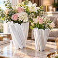 Duo de vases blancs sculpturaux plissés à ouverture ondulée, avec bouquets de fleurs